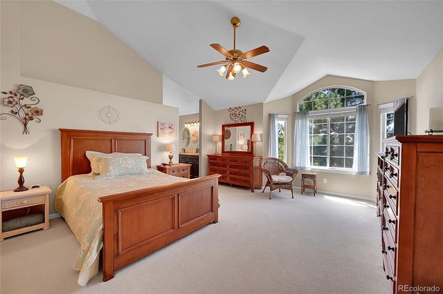 a spacious bedroom with a bed and a chandelier