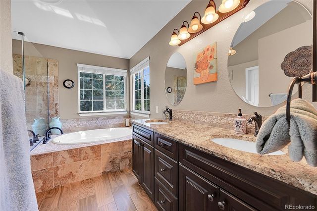 a bathroom with a granite countertop sink a large mirror and bathtub