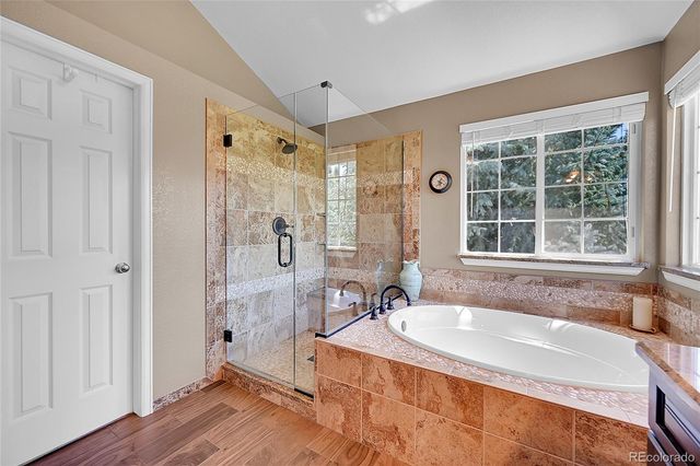 a bathroom with a granite countertop tub sink and mirror