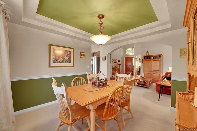 a dining room with furniture a chandelier and window