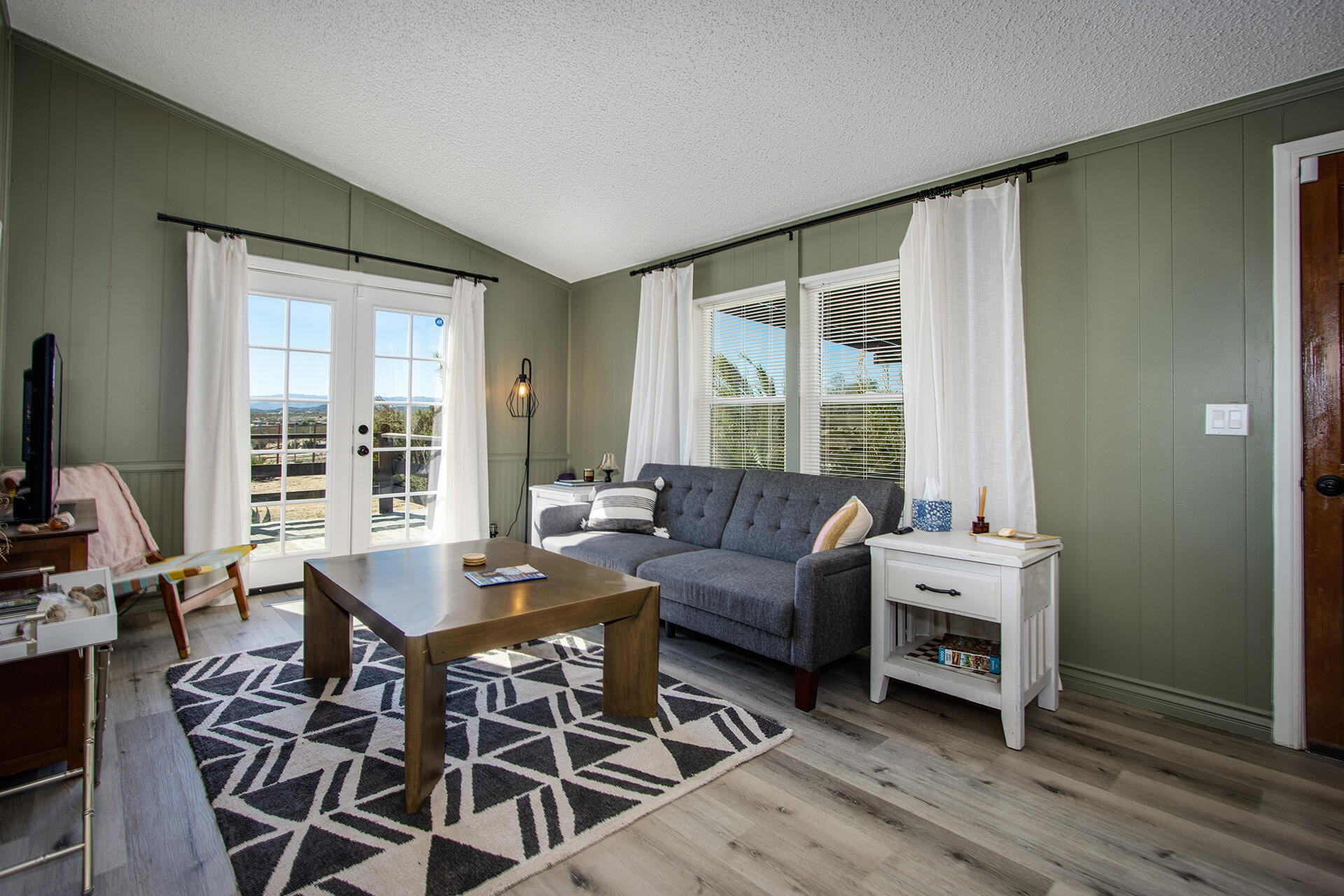66621 Daisy Lane Joshua Tree, CA 92252 - Photo 30 of 53 a living room with furniture and a floor to ceiling window