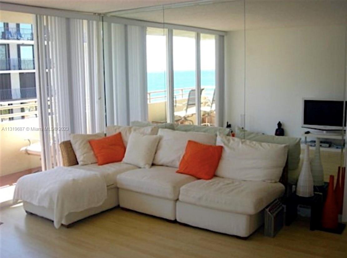 8911 Collins Avenue, Unit 1004 Surfside, FL 33154 - Photo 11 of 20 a living room with a couch and a flat screen tv