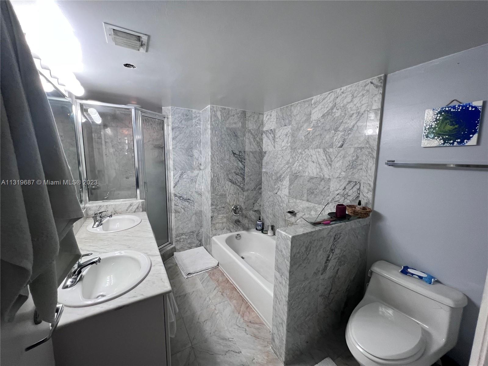 8911 Collins Avenue, Unit 1004 Surfside, FL 33154 - Photo 14 of 20 a bathroom with a sink toilet and shower