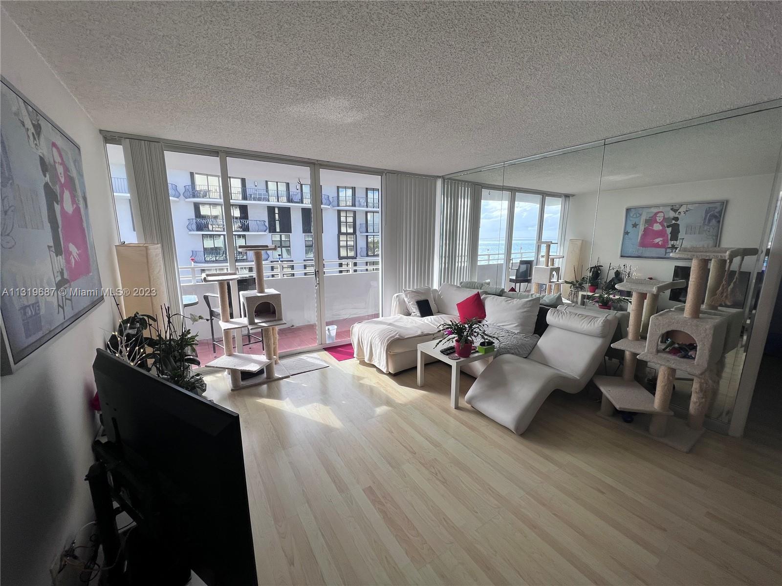 8911 Collins Avenue, Unit 1004 Surfside, FL 33154 - Photo 16 of 20 a living room with furniture and a window