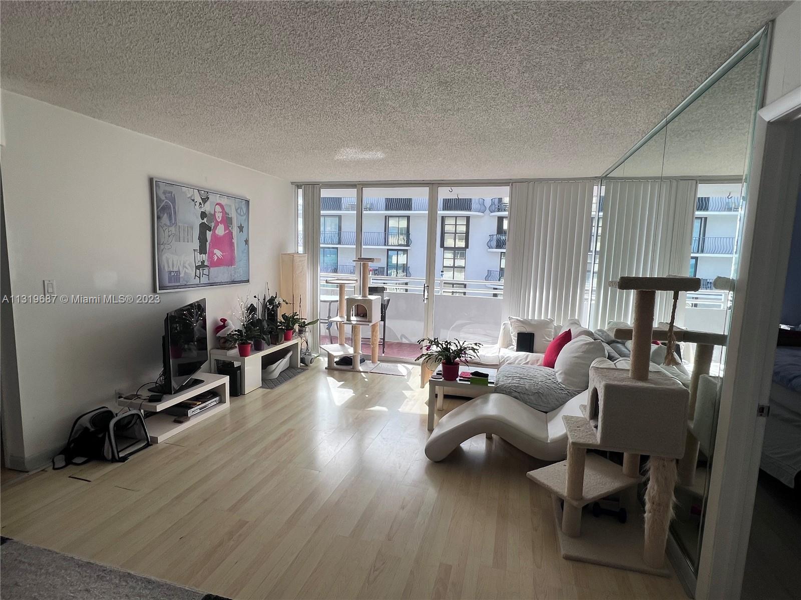 8911 Collins Avenue, Unit 1004 Surfside, FL 33154 - Photo 20 of 20 a living room with furniture and a wooden floor