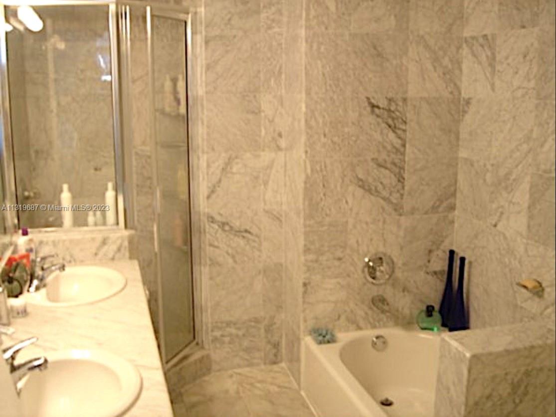 8911 Collins Avenue, Unit 1004 Surfside, FL 33154 - Photo 7 of 20 a bathroom with a sink and a tub