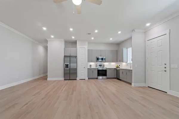 a view of an empty room with window and wooden floor