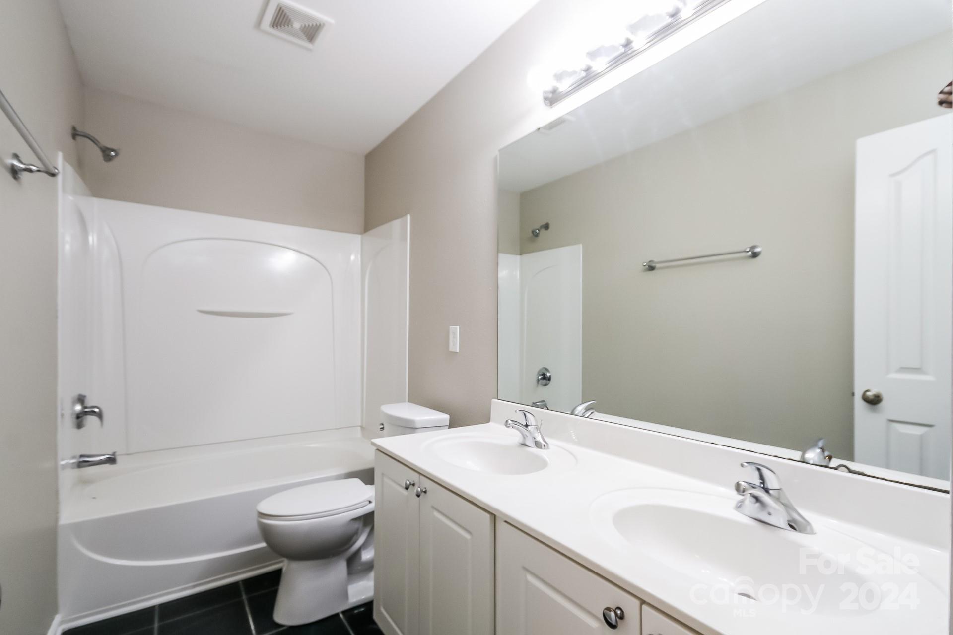 2315 Gooseberry Road Charlotte, NC 28208 - Photo 20 of 22 a bathroom with a toilet a sink a mirror a bathtub and vanity