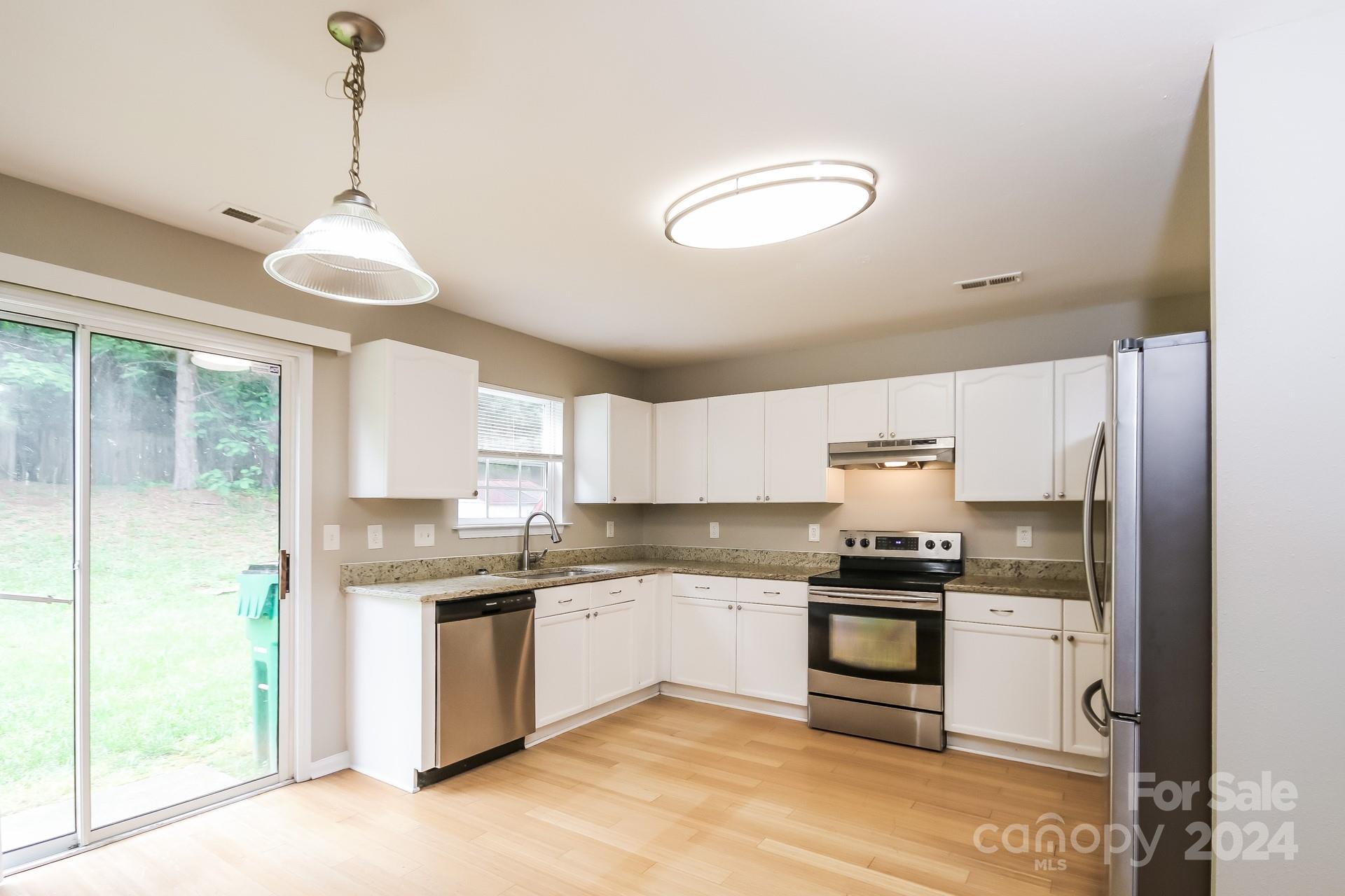 2315 Gooseberry Road Charlotte, NC 28208 - Photo 9 of 22 a kitchen with granite countertop a sink cabinets stainless steel appliances and a window