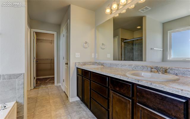 11293 Avena Road Peyton, CO 80831 - Photo 19 of 34 5 piece master bathroom features a raised height vanity and in-bathroom linen closet along with the separate toilet room