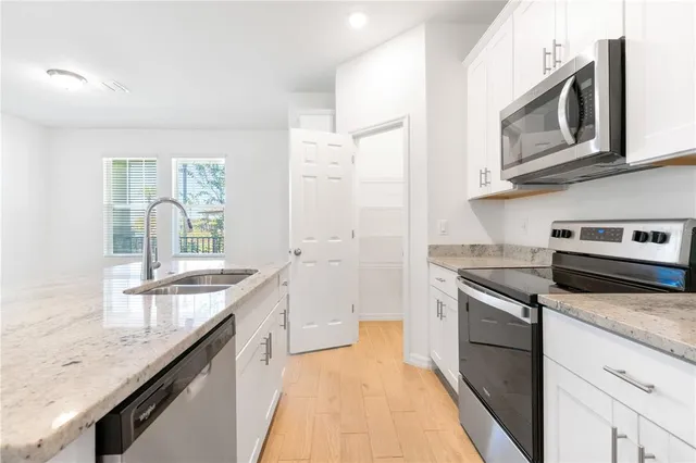 a kitchen with stainless steel appliances granite countertop a sink stove and refrigerator