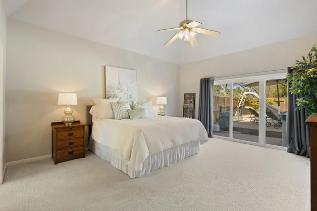 a spacious bedroom with a large bed and a chandelier