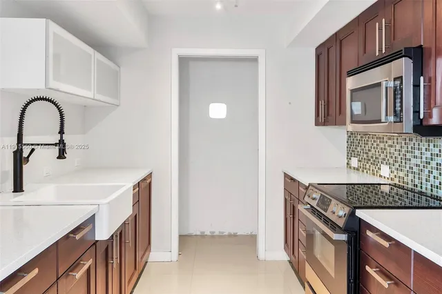 a kitchen with a sink and a stove top oven