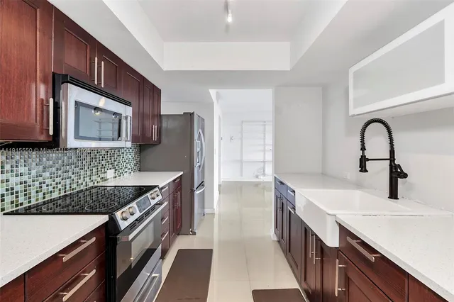 a kitchen with stainless steel appliances granite countertop a sink stove and refrigerator