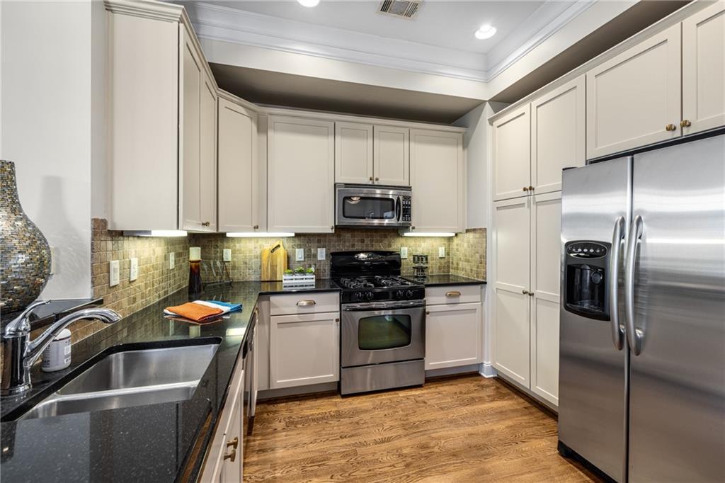 1258 DeKalb Avenue Northeast, Unit 135 Atlanta, GA 30307 - Photo 15 of 45 a kitchen with stainless steel appliances granite countertop a sink stove and refrigerator