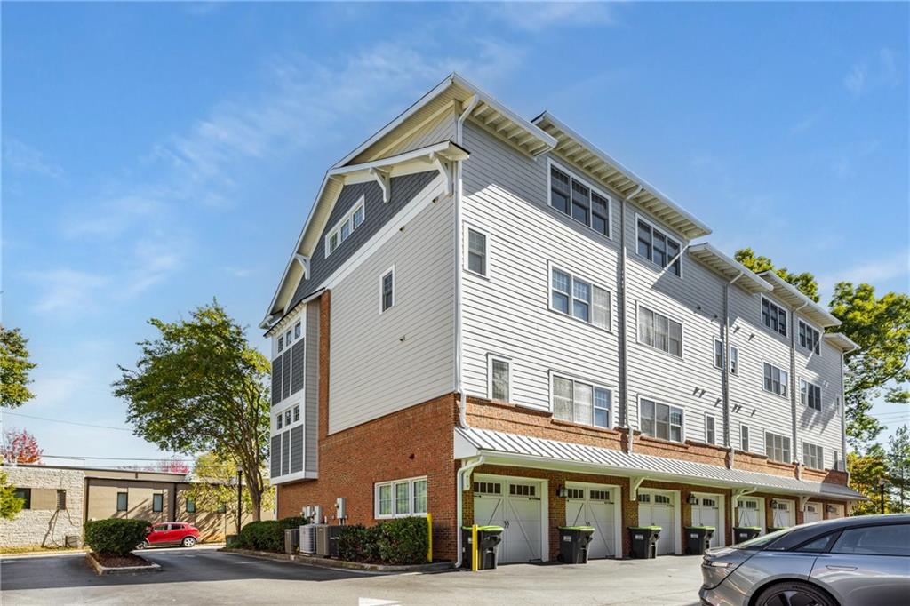 1258 DeKalb Avenue Northeast, Unit 135 Atlanta, GA 30307 - Photo 38 of 45 a front view of a building with lot of cars and trees
