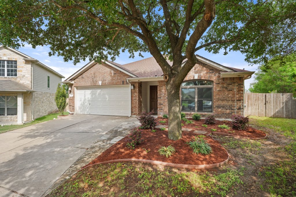 11508 Gossamer Drive Austin, TX 78754 - Photo 14 of 40 Brick residence featuring an attached two-car garage, front yard landscaping, and a double wide concrete driveway.