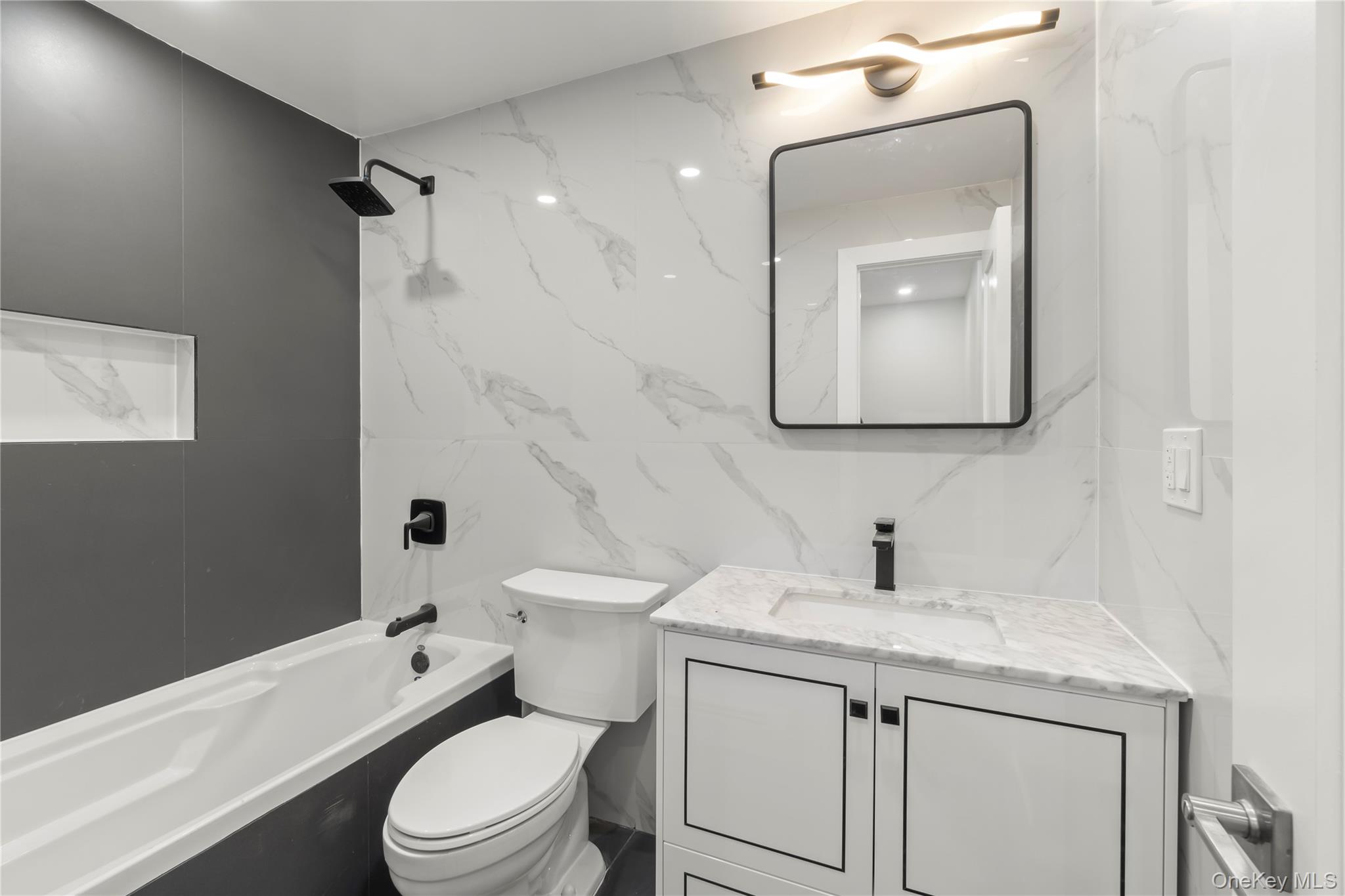 249-09 Mayda Road Queens, NY 11422 - Photo 10 of 28 a bathroom with a granite countertop toilet a sink and a bathtub