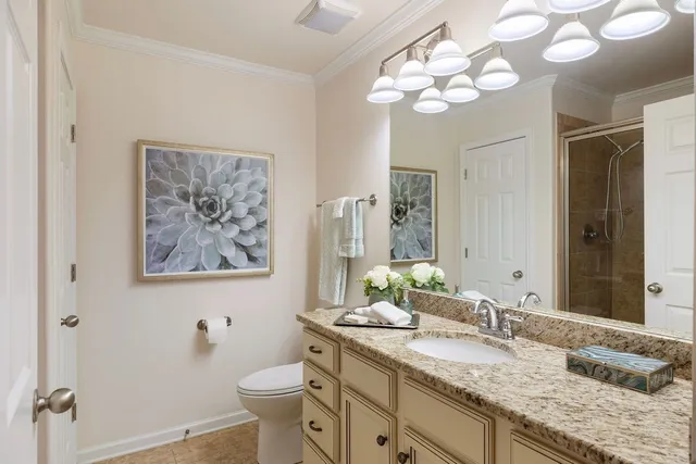 a bathroom with a granite countertop double vanity sink mirror and toilet