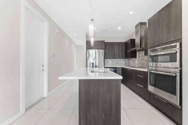 a kitchen with stainless steel appliances granite countertop a sink and a refrigerator