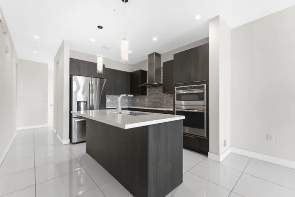 a kitchen with stainless steel appliances granite countertop a refrigerator and a sink