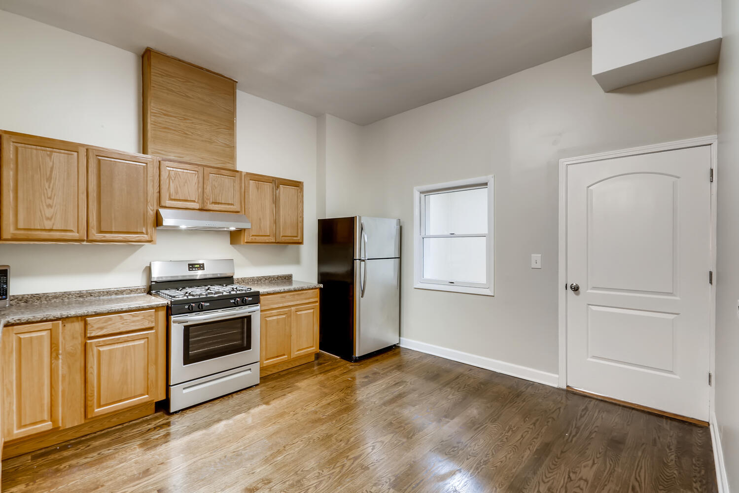 7046 North Clark Street, Unit 2 Chicago, IL 60626 - Photo 4 of 11 a kitchen with stainless steel appliances granite countertop a stove and a refrigerator