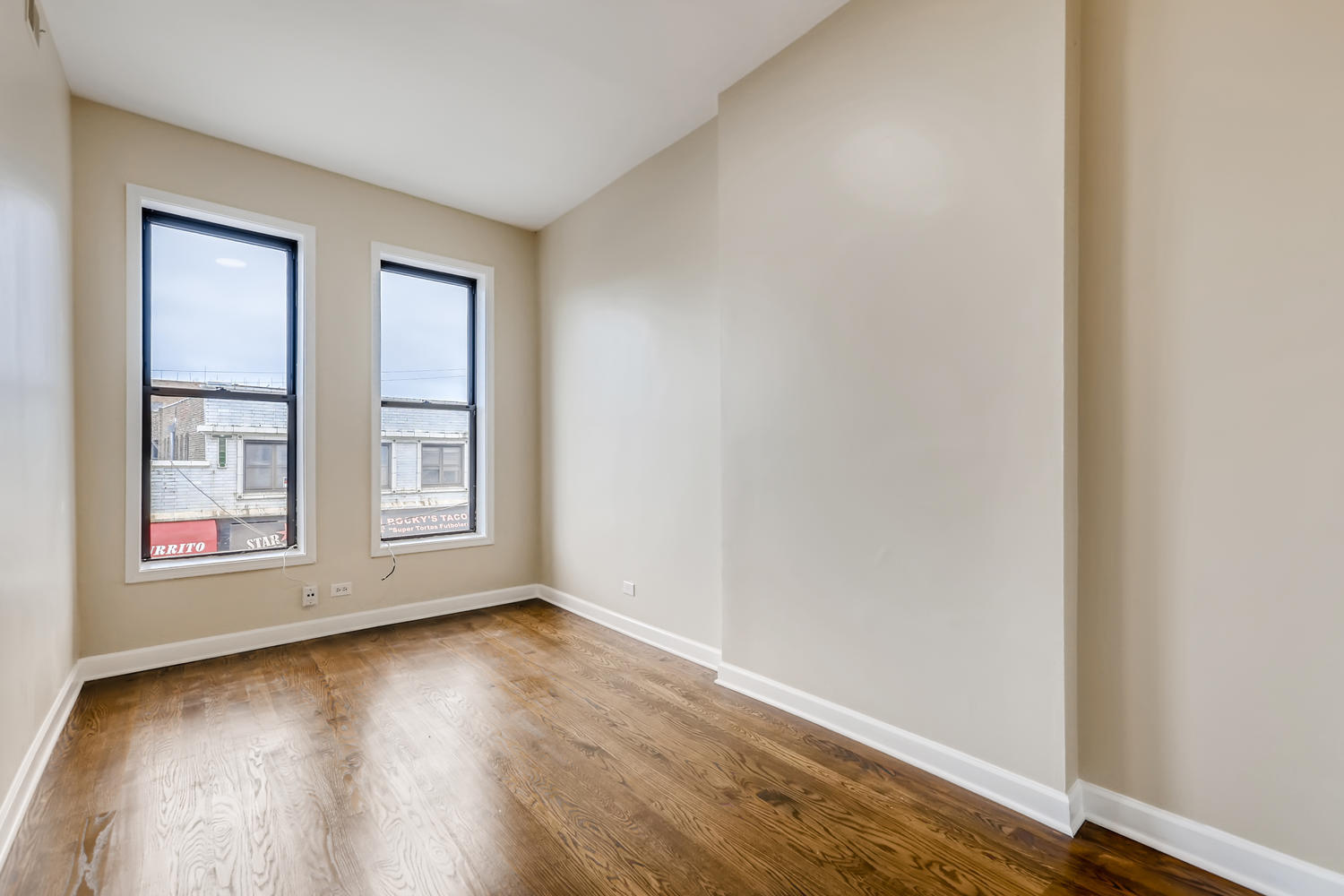 7046 North Clark Street, Unit 2 Chicago, IL 60626 - Photo 9 of 11 an empty room with wooden floor and windows