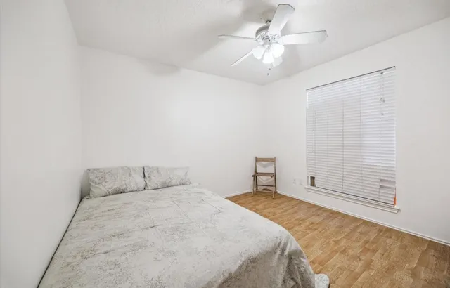 a bedroom with a bed and a ceiling fan