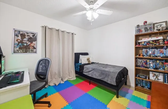 a bedroom with a bed bookshelf and a window