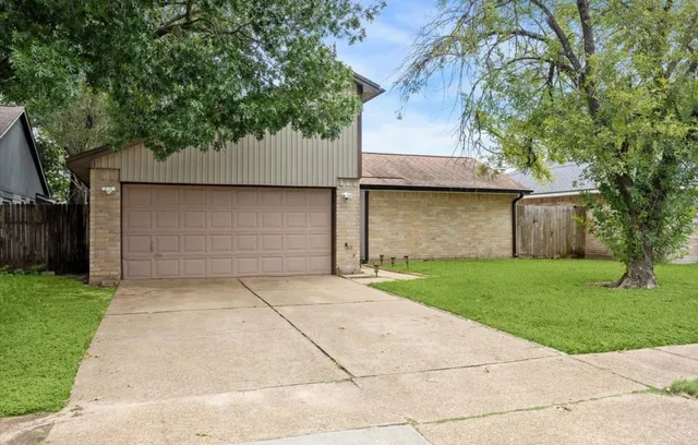 front view of house with a yard and trees
