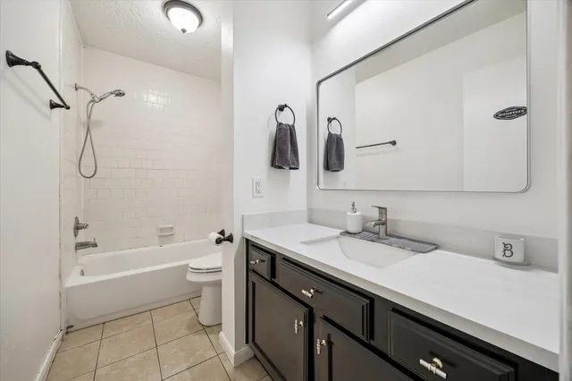 a bathroom with a granite countertop sink a toilet and shower