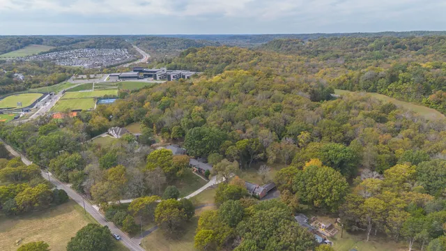 a large kitchen with a stove a sink dishwasher a refrigerator and white cabinets with wooden floor