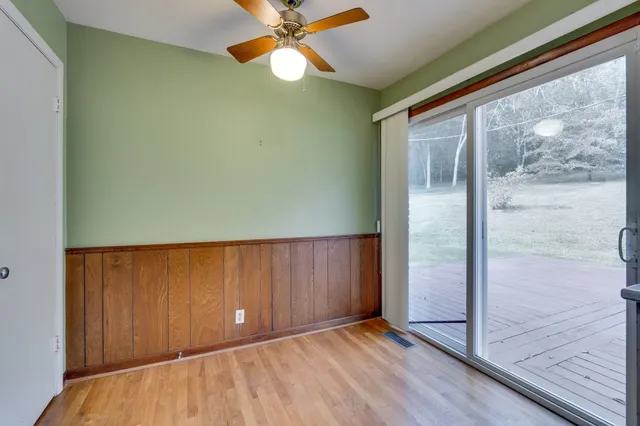 a view of a refrigerator in kitchen and an empty room
