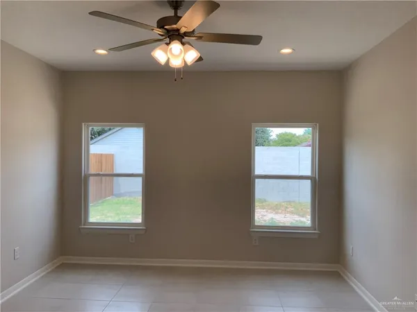 an empty room with wooden floor and mirror