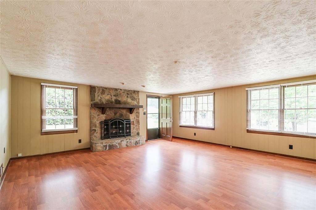 1291 Stephens Street Southwest Lilburn, GA 30047 - Photo 19 of 22 an empty room with windows fireplace and windows