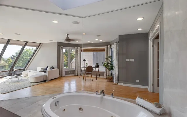 a bathroom with a tub a sink and mirror