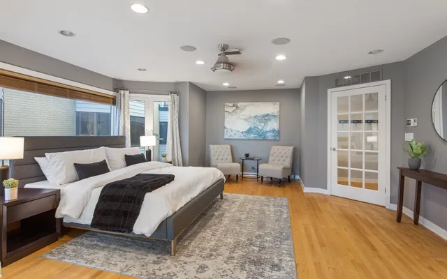 a spacious bedroom with a bed a table and large window