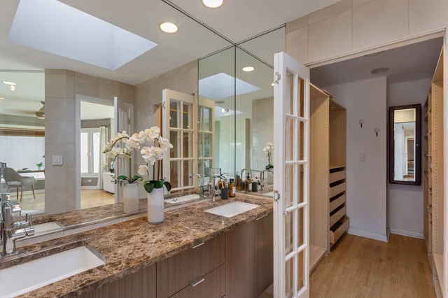 a large bathroom with a granite countertop double vanity sink a mirror and a shower