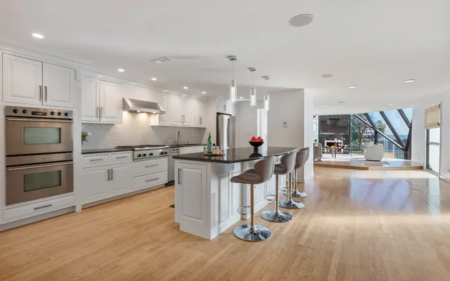 a kitchen with stainless steel appliances kitchen island granite countertop a stove a sink and a refrigerator