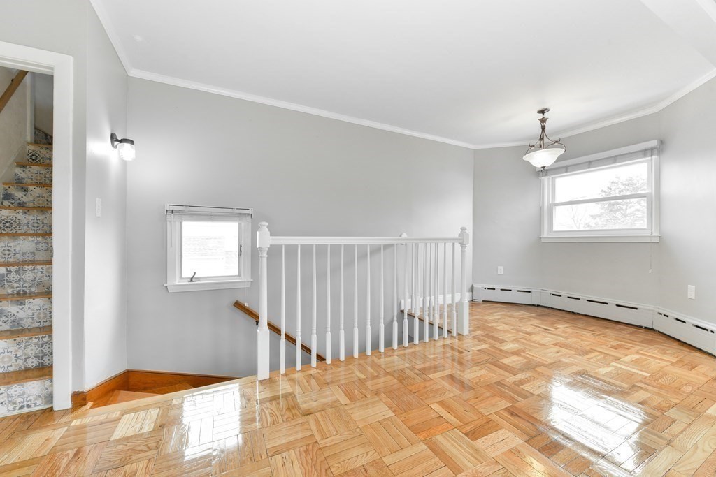 40 Bosson Street, Unit 2 Revere, MA 02151 - Photo 4 of 13 a view of a bedroom with wooden floor and windows