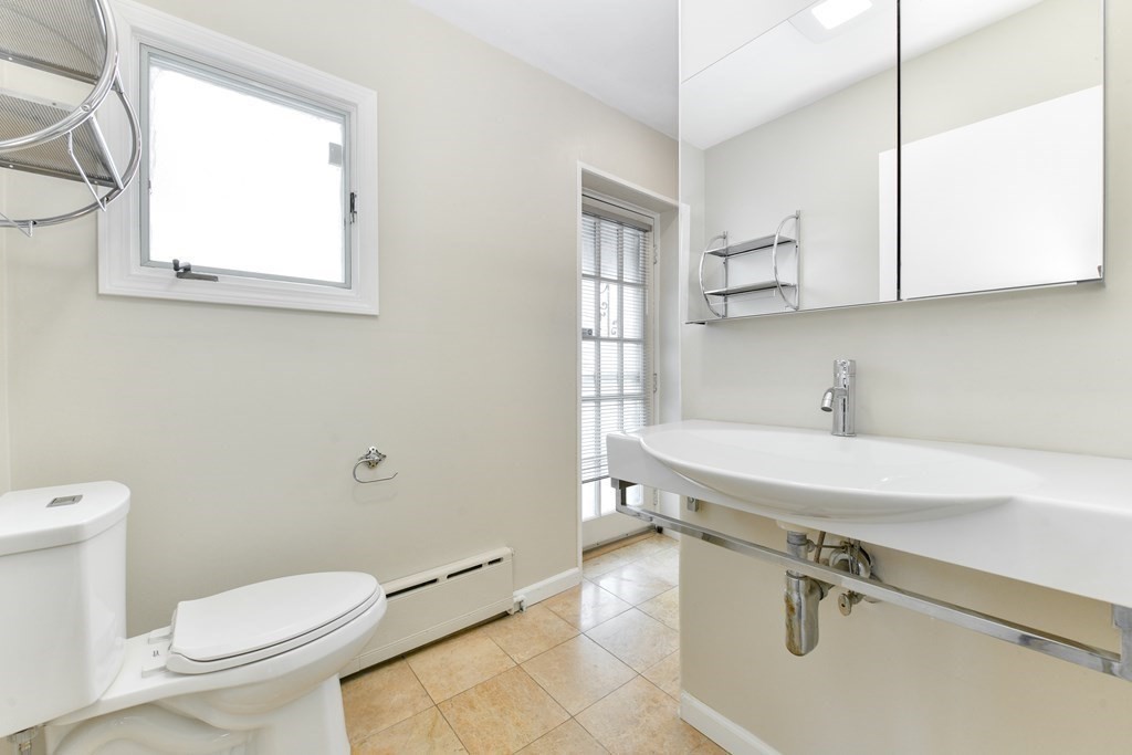 40 Bosson Street, Unit 2 Revere, MA 02151 - Photo 5 of 13 a bathroom with a sink a toilet and a mirror