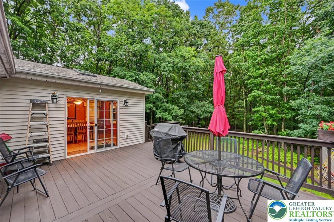386 Upper Rdg Drive Effort, PA 18330 - Photo 43 of 56 An inviting outdoor deck provides ample space for entertaining amidst a verdant, wooded backdrop.