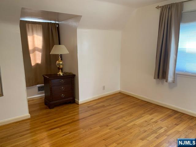 279 Slocum Way Fort Lee, NJ 07024 - Photo 13 of 20 an empty room with wooden floor and mirror