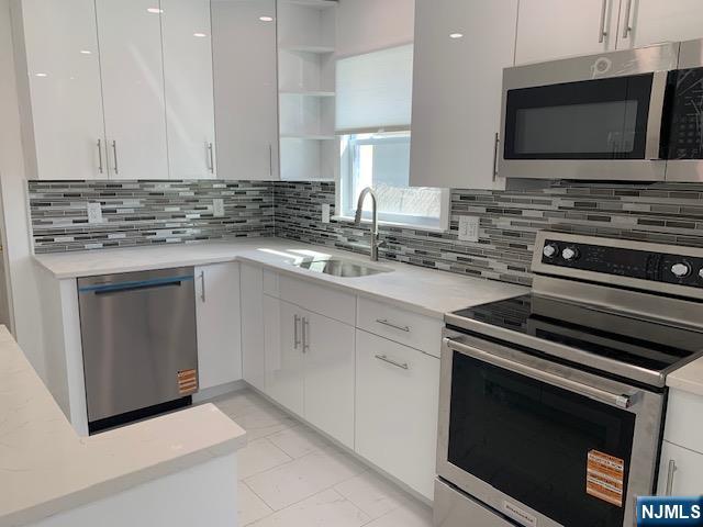 279 Slocum Way Fort Lee, NJ 07024 - Photo 4 of 20 a kitchen with a stove and a microwave