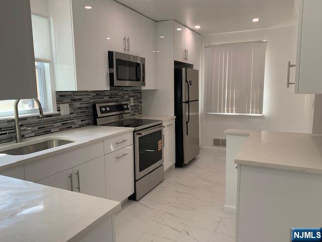279 Slocum Way Fort Lee, NJ 07024 - Photo 6 of 20 a kitchen with stainless steel appliances a refrigerator sink and microwave
