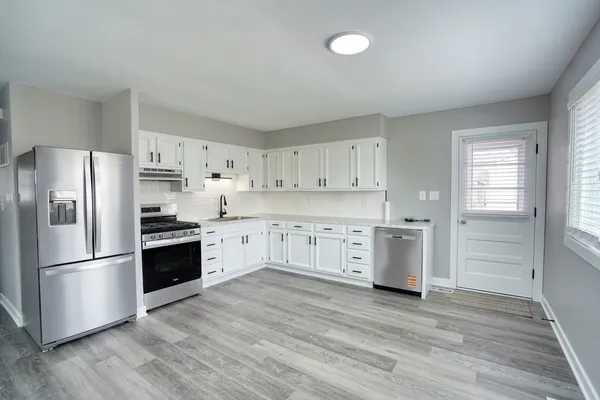 a kitchen with white cabinets and stainless steel appliances