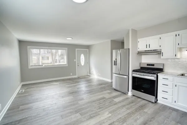a view of kitchen with stainless steel appliances granite countertop a stove a sink and a refrigerator