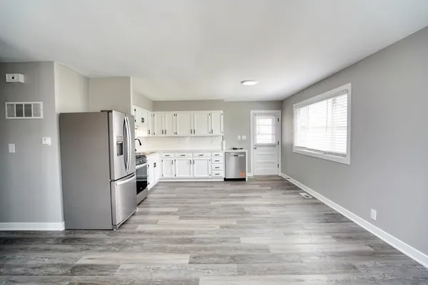 a view of a kitchen with a refrigerator cabinets and wooden floor