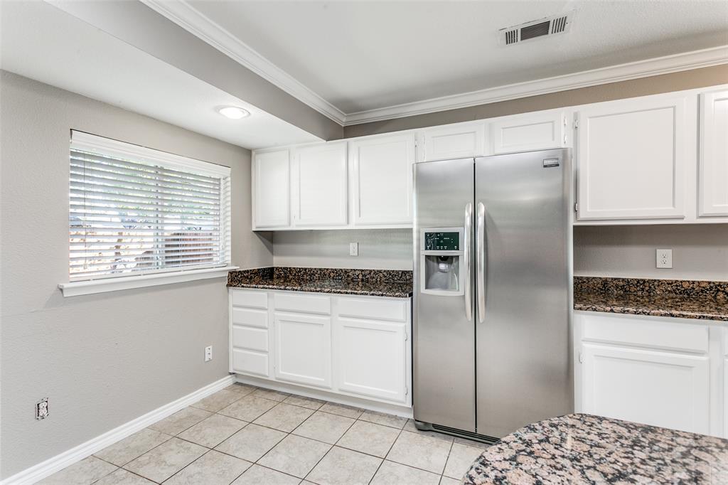 845 Lovers Lane Grapevine, TX 76051 - Photo 13 of 24 a kitchen with granite countertop a refrigerator and a stove top oven