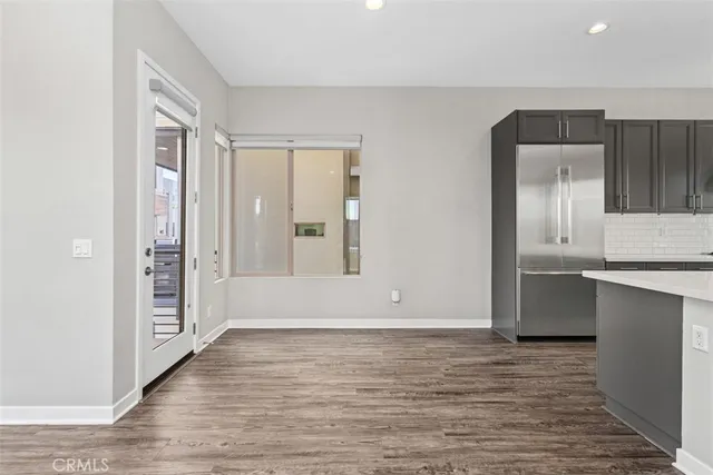 a large kitchen with a center island wooden floor stainless steel appliances and cabinets